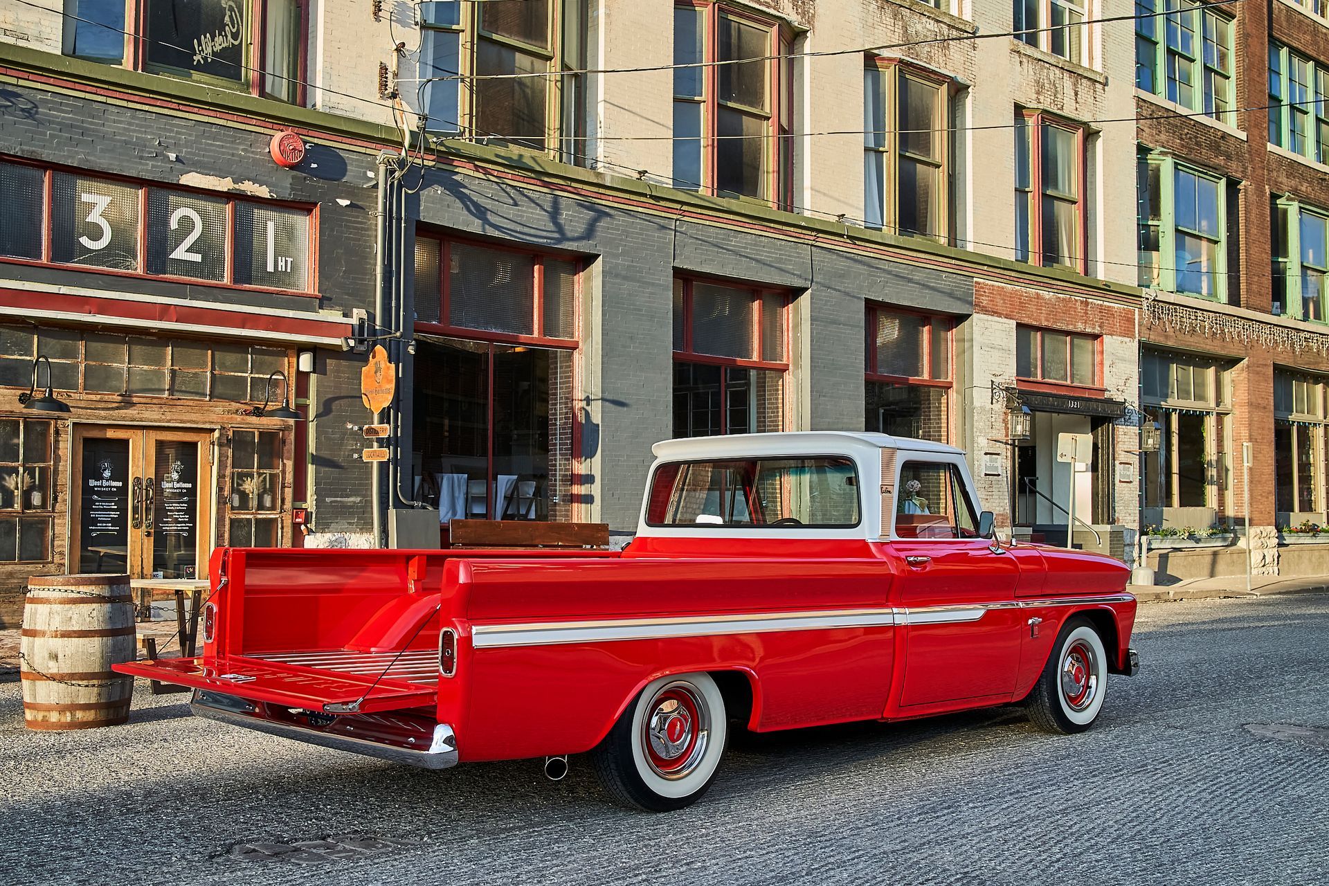 A red truck is parked in front of a building with the number 321 on it