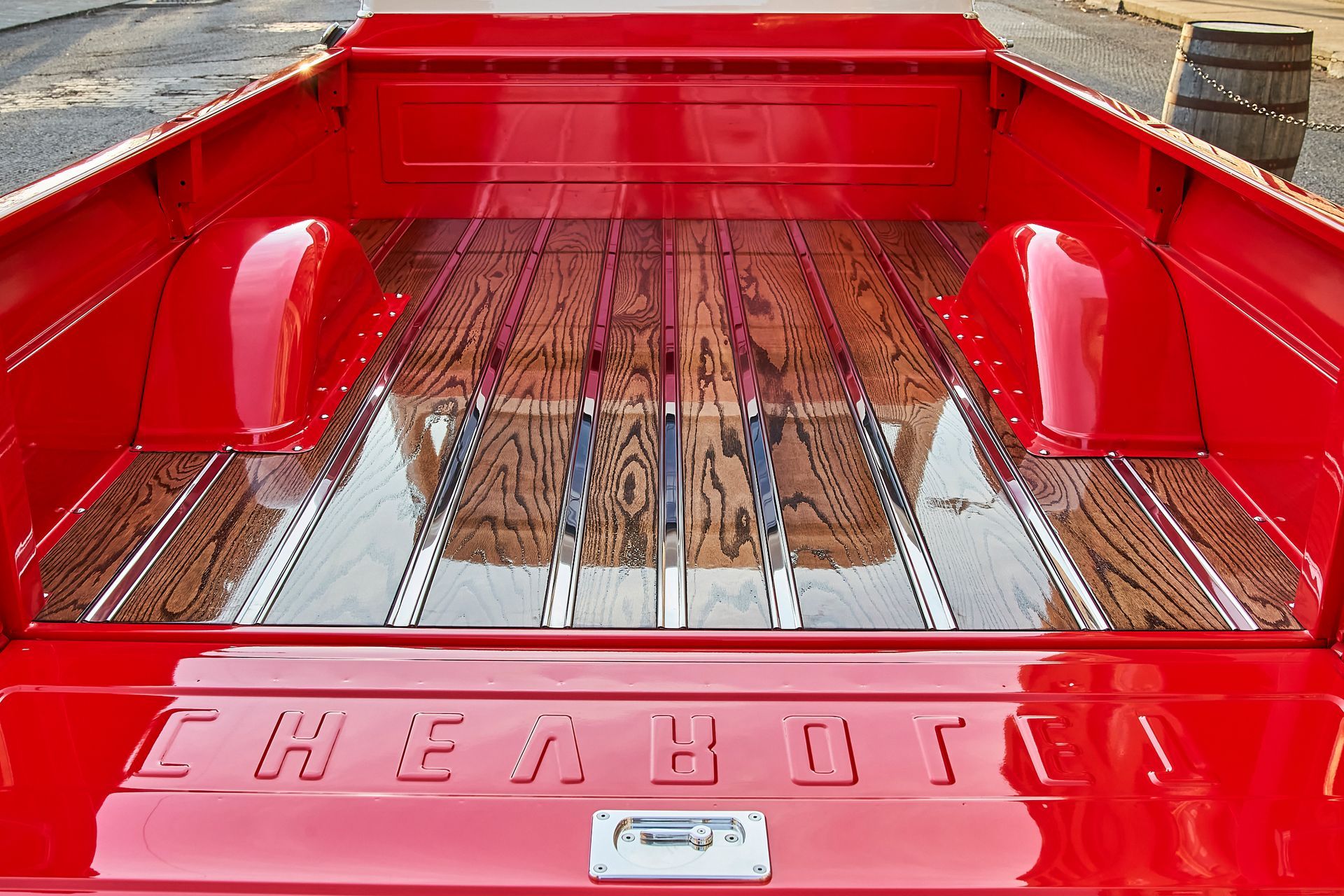 The back of a red chevy truck with a wooden floor