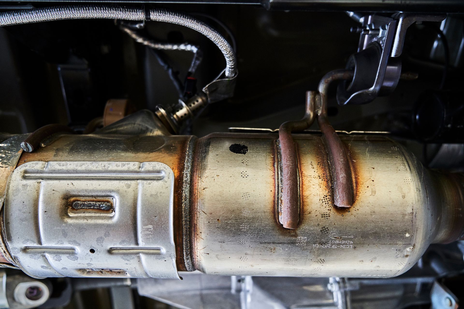 A close up of a exhaust pipe on the underside of a car.
