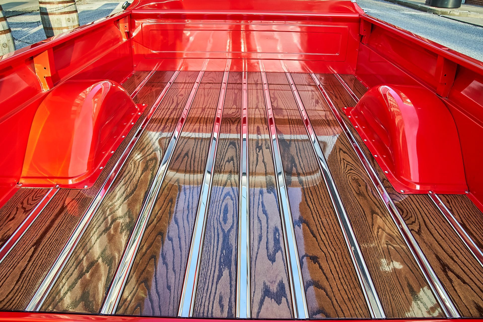 The back of a red truck with a wooden floor