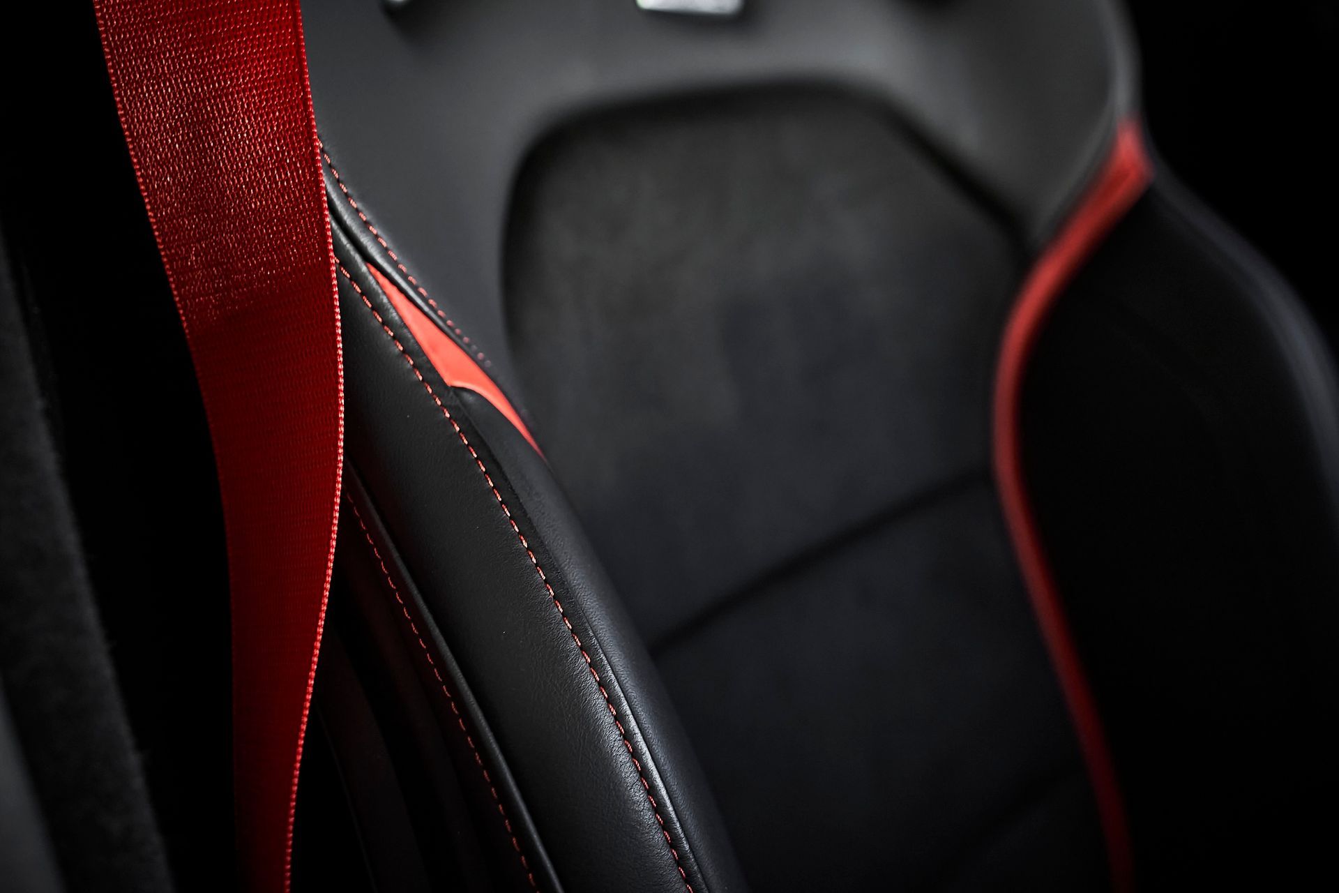 A close up of a car seat with a red stitching