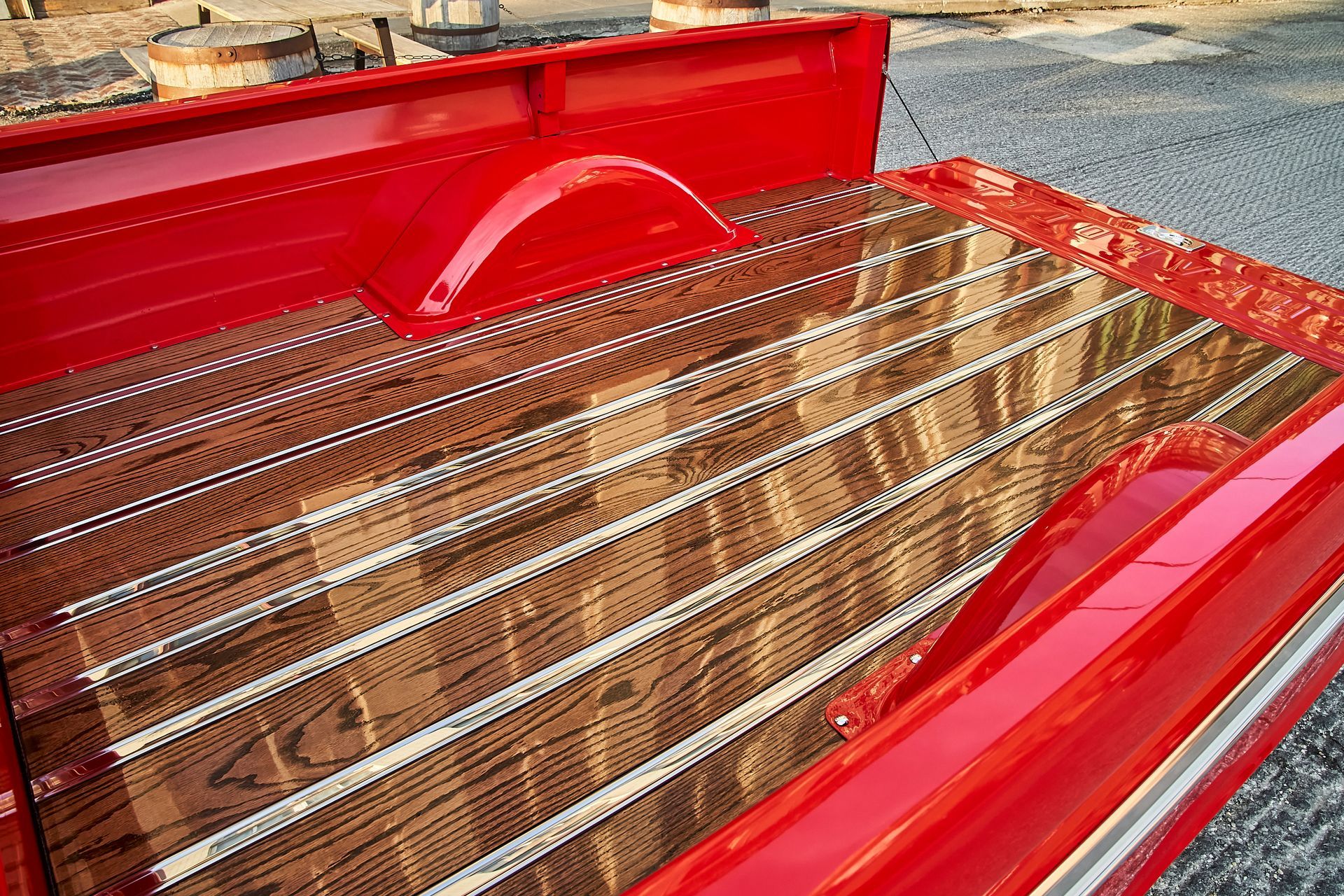 The back of a red truck with a wooden bed