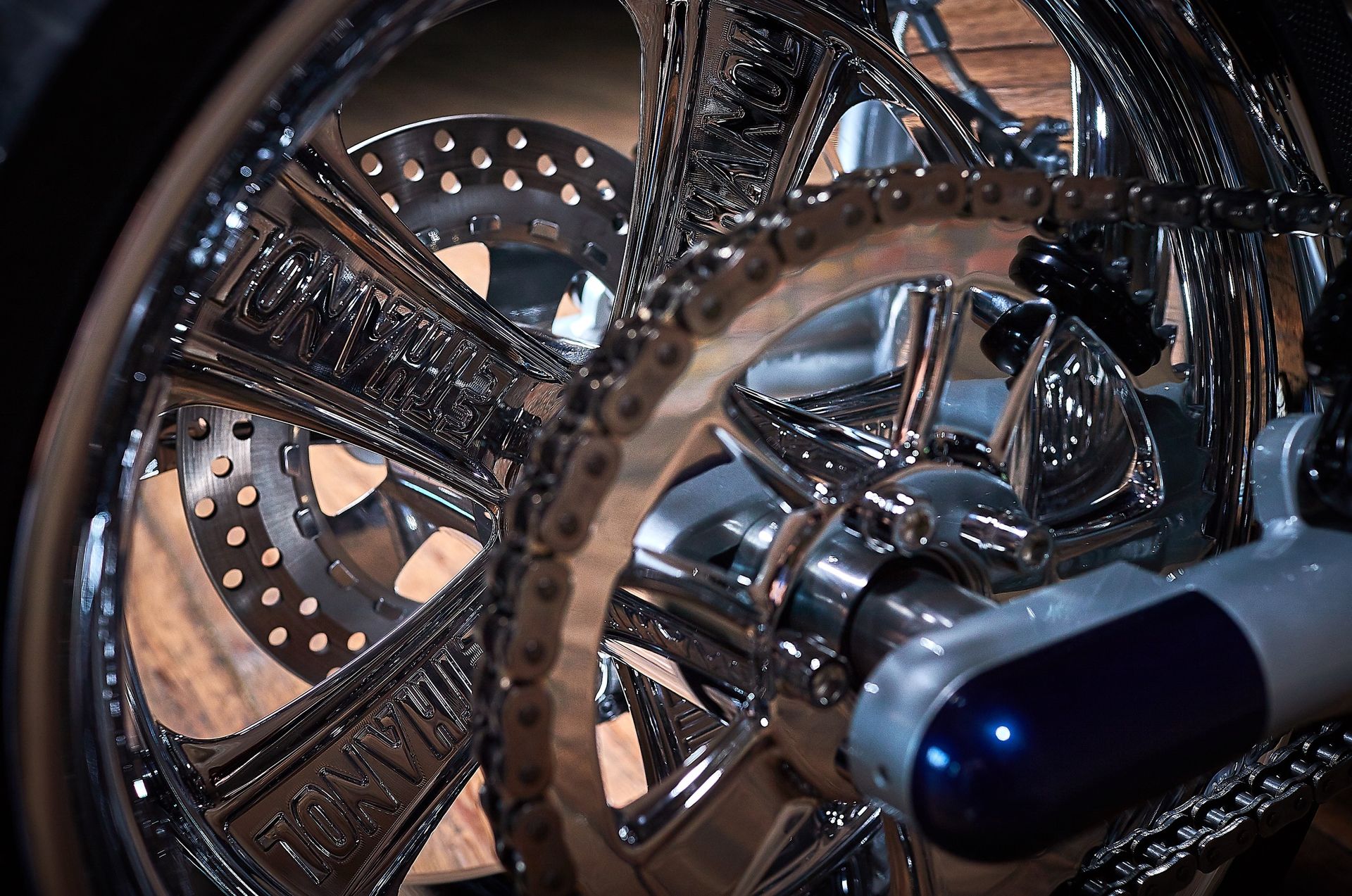 A close up of a motorcycle wheel with a chain around it