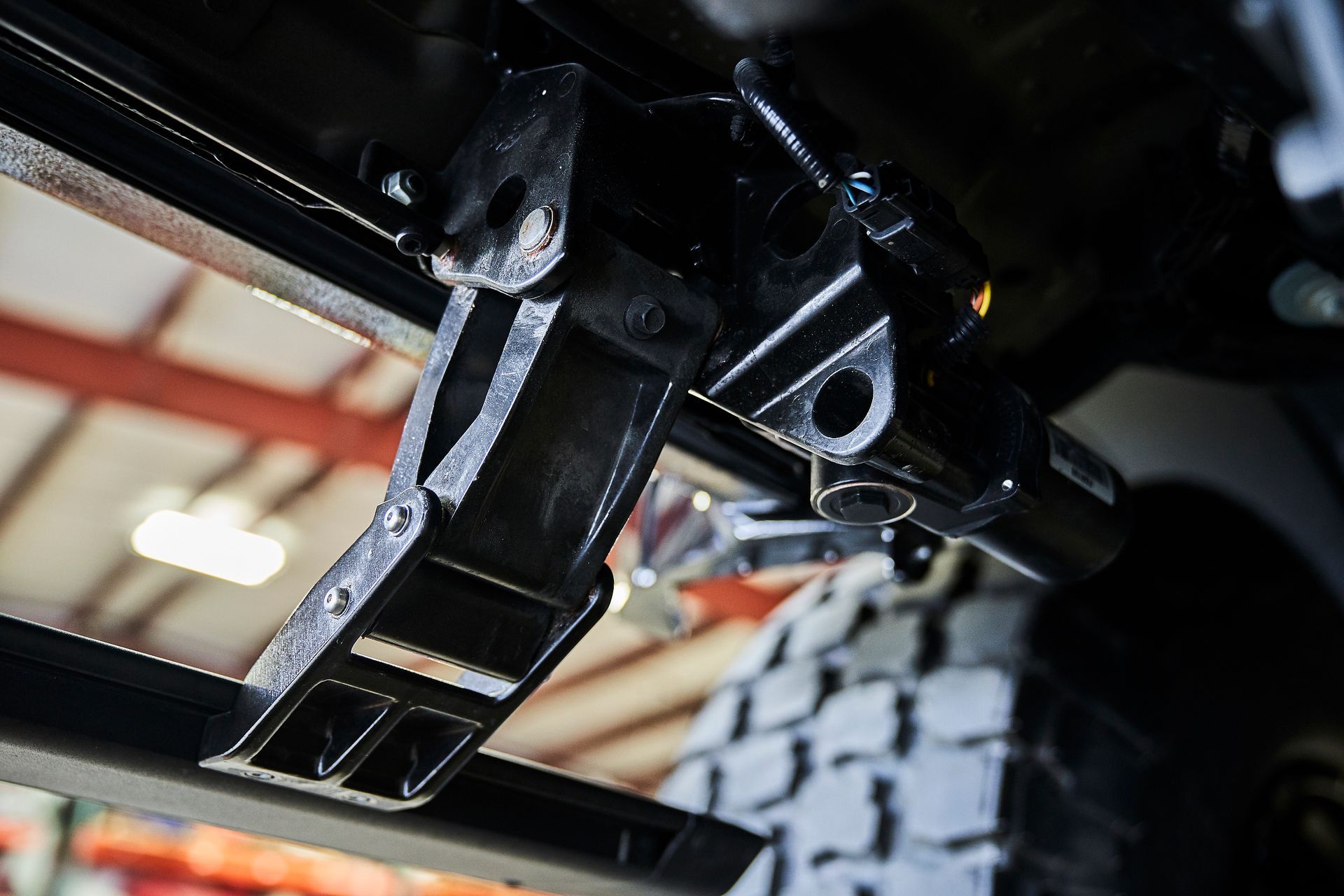 A close up of a trailer hitch on a vehicle in a garage.