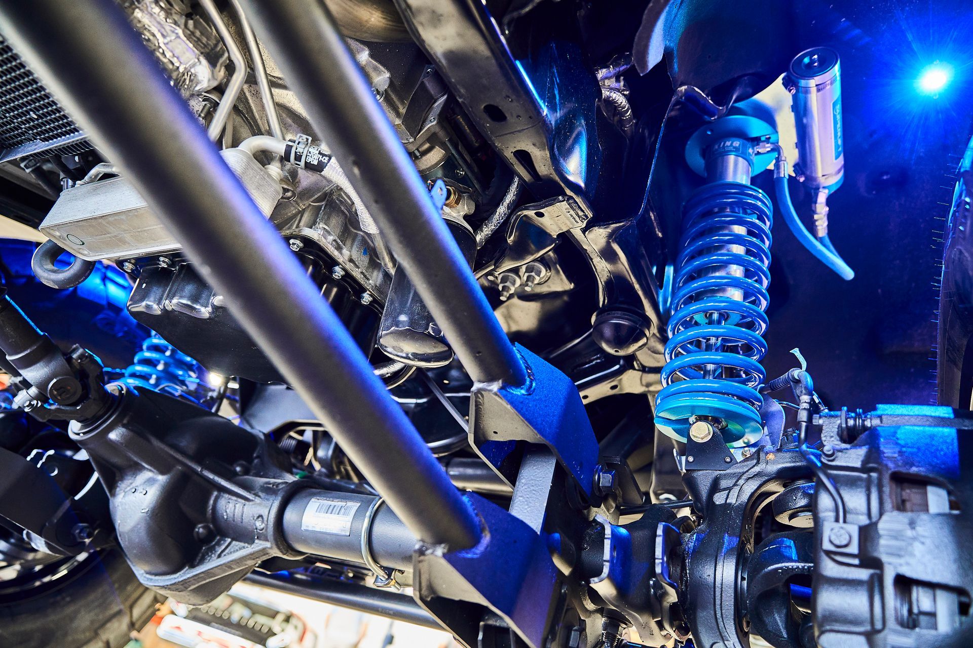 A close up of the underside of a car with blue lights on it.