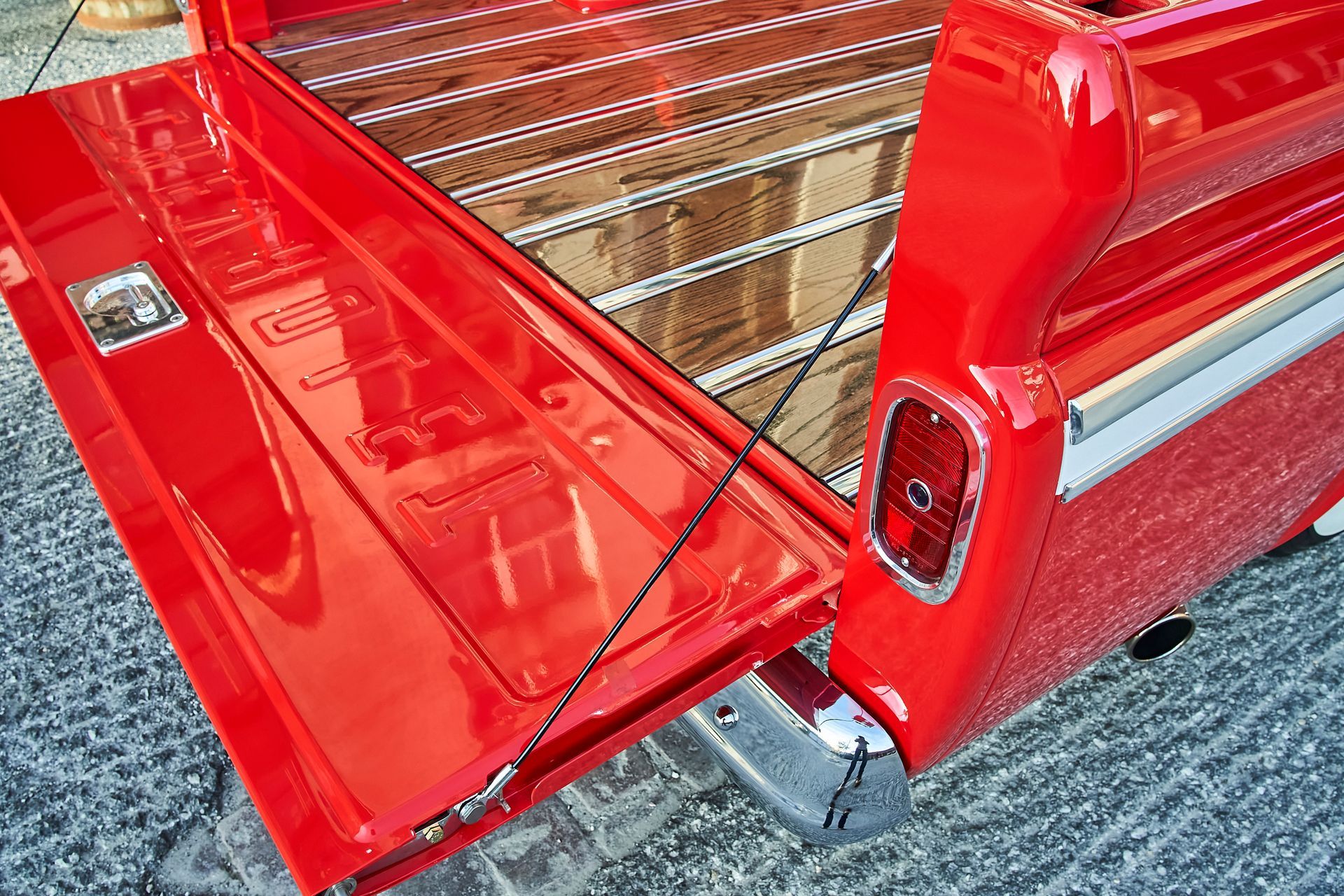 The back of a red truck with the tailgate open.