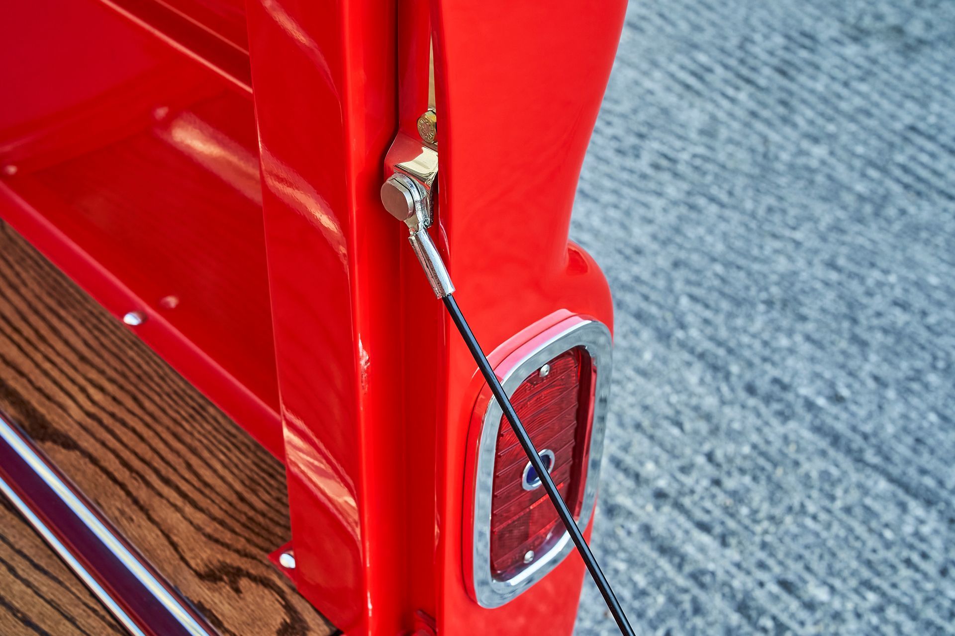 A close up of a red truck with a rope attached to it.