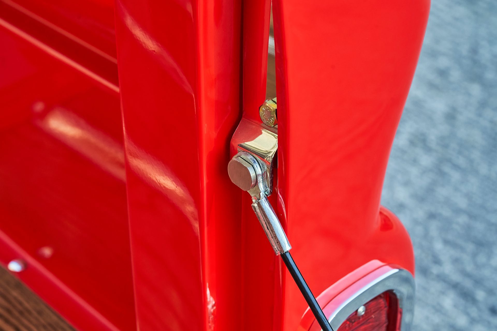 A close up of a red truck with a hose attached to it.