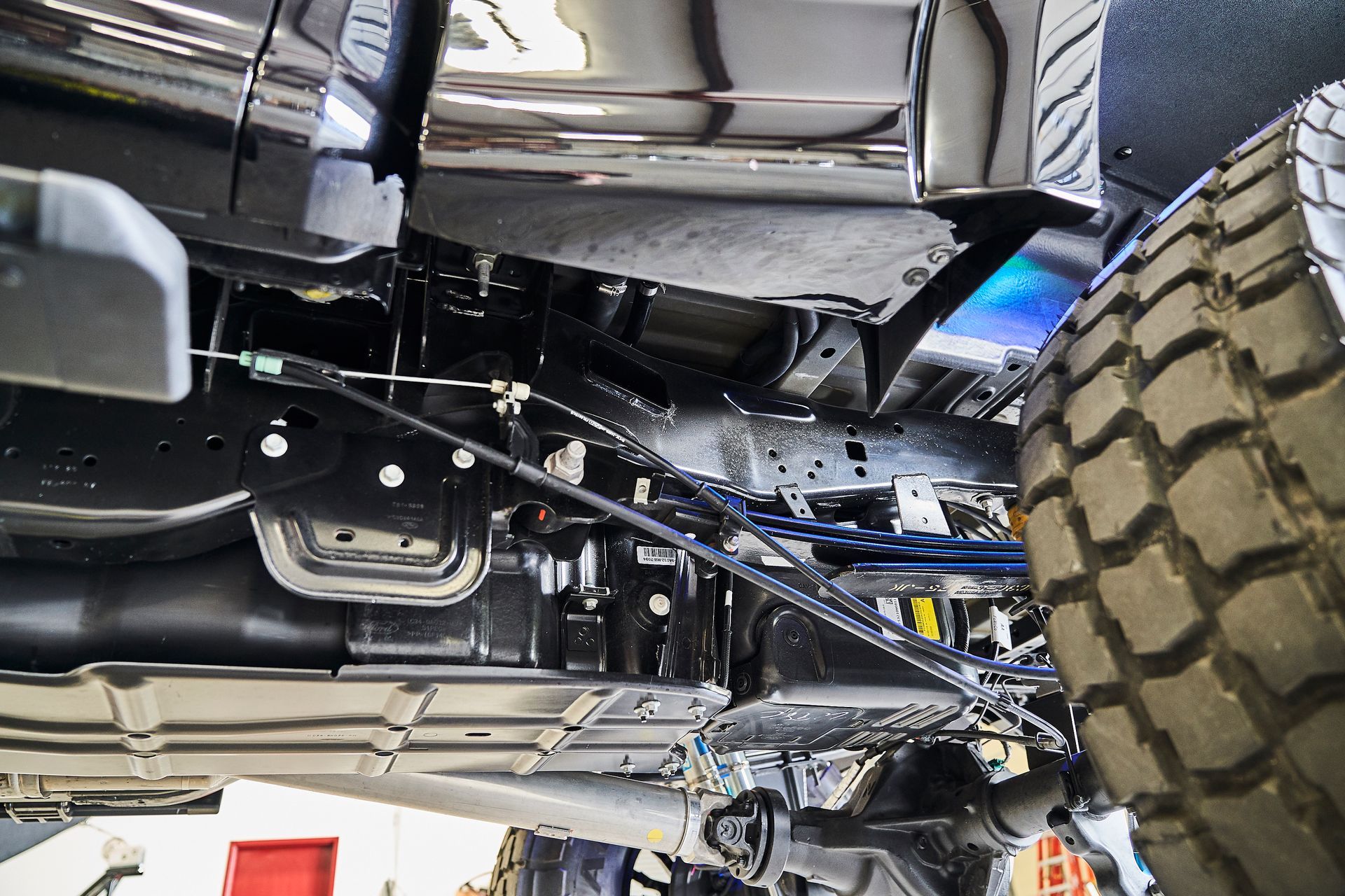 A close up of the underside of a truck in a garage.