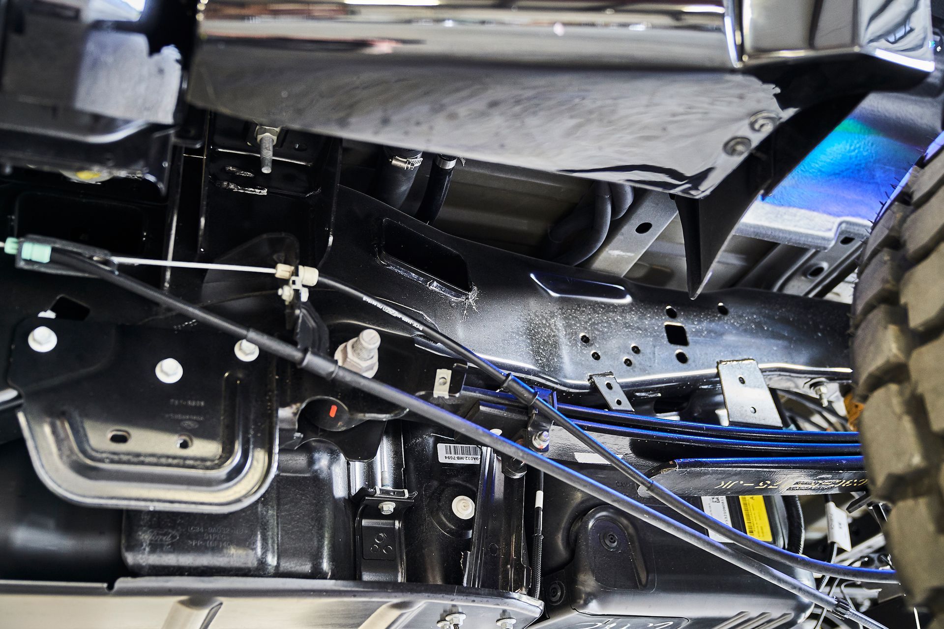 A close up of the underside of a truck with a lot of wires coming out of it.