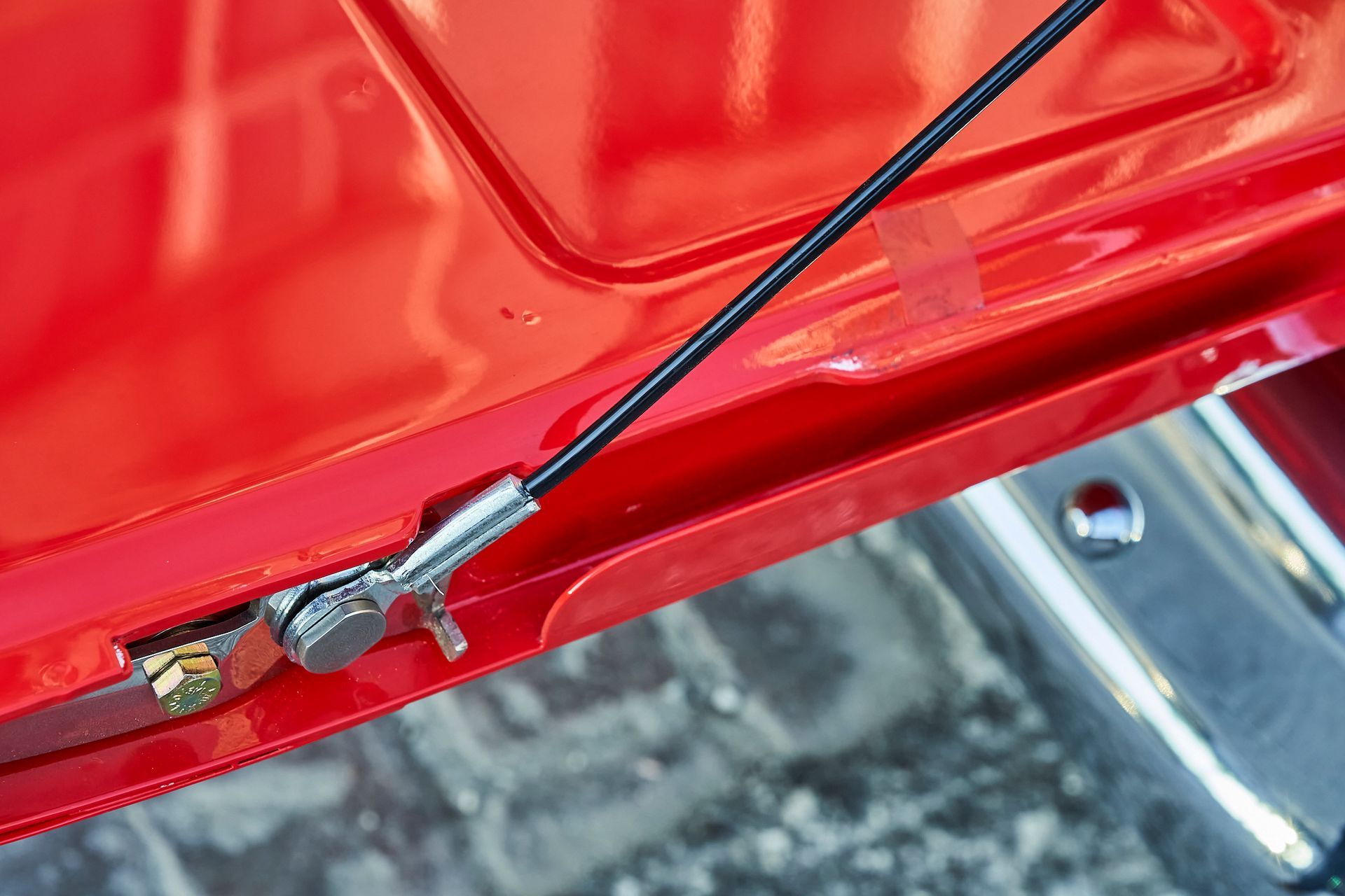 A close up of a red car with a black antenna attached to it.