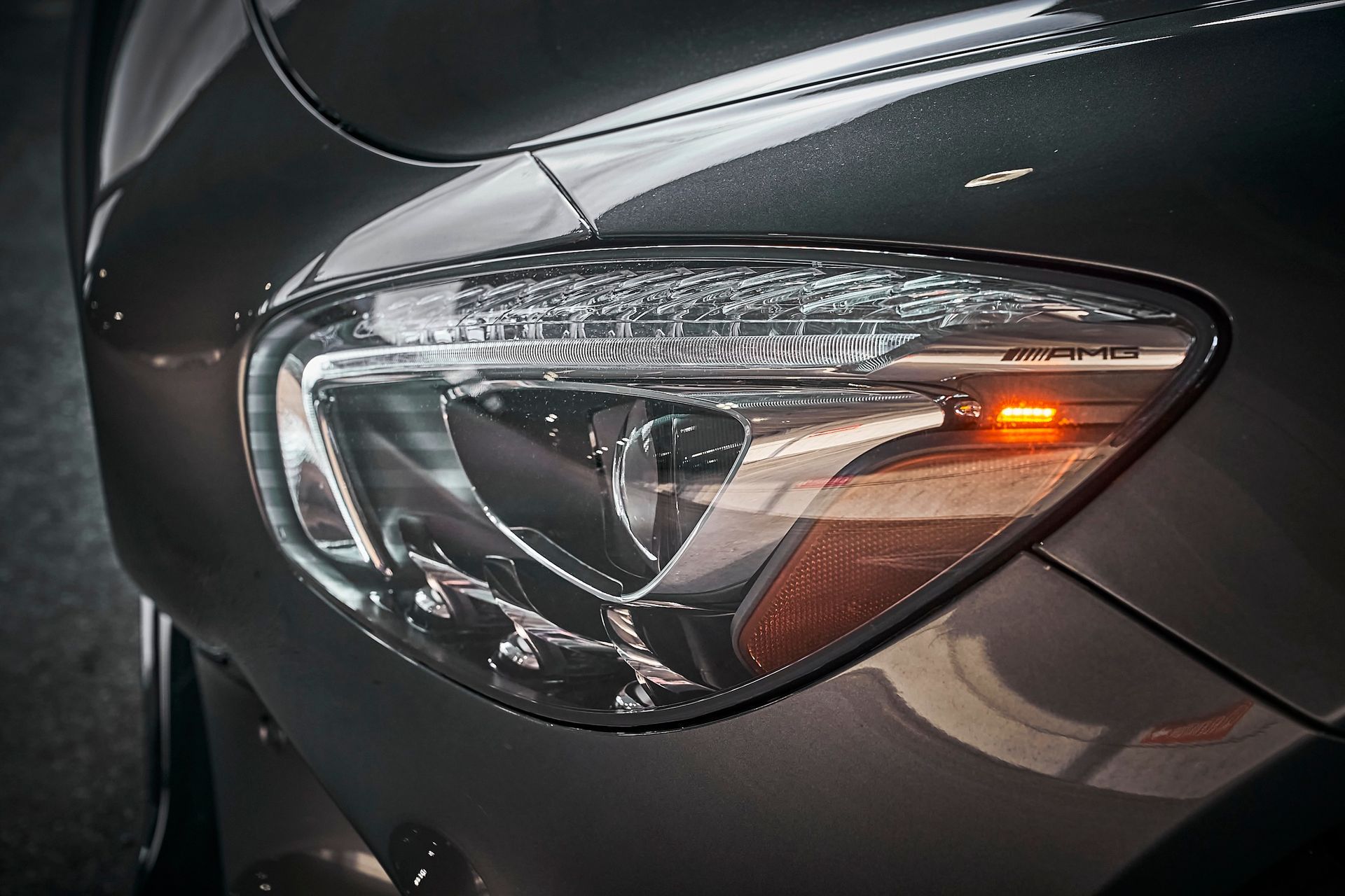 A close up of a car 's headlight on a dark background.