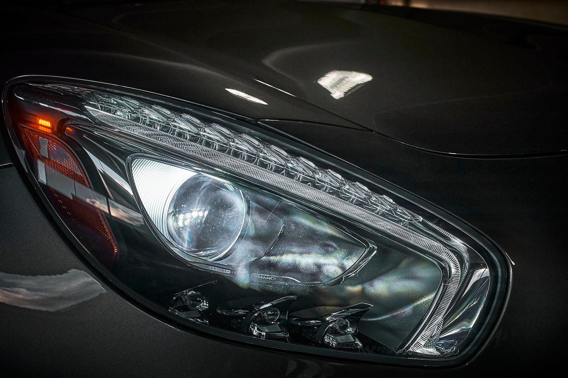 A close up of the headlight of a black car.