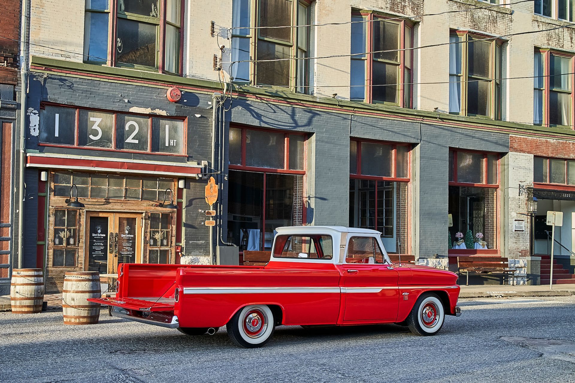 A red truck is parked in front of a building.