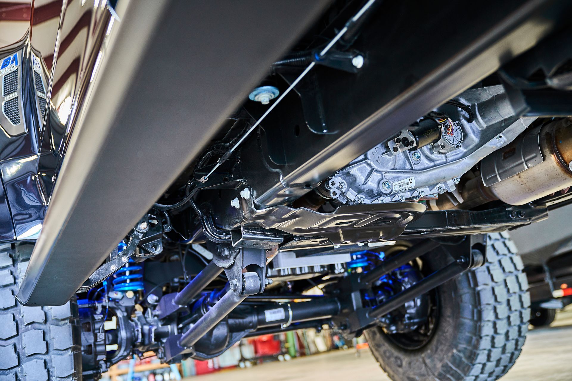 A close up of the underside of a truck in a garage.