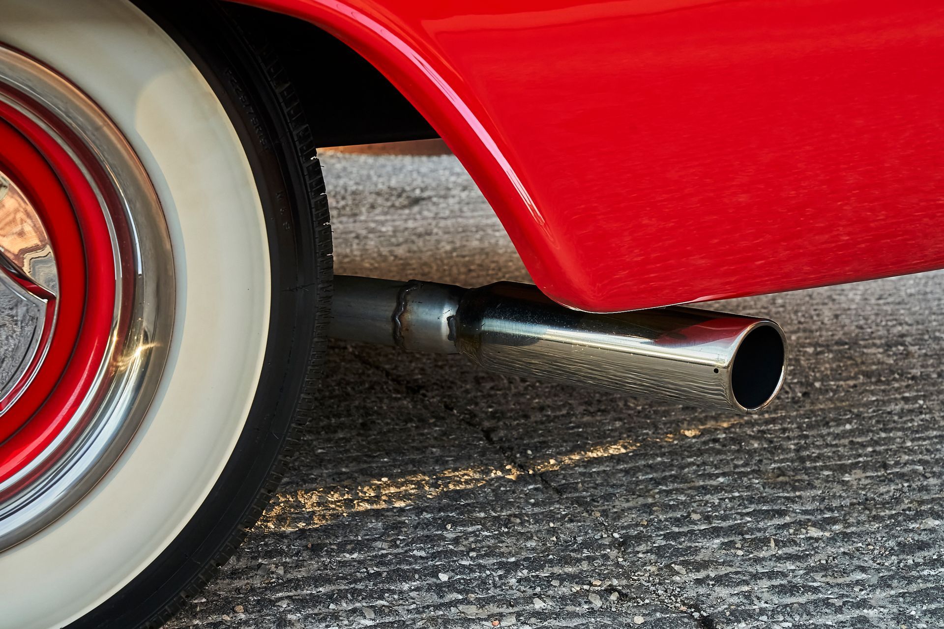 A close up of a red car exhaust pipe