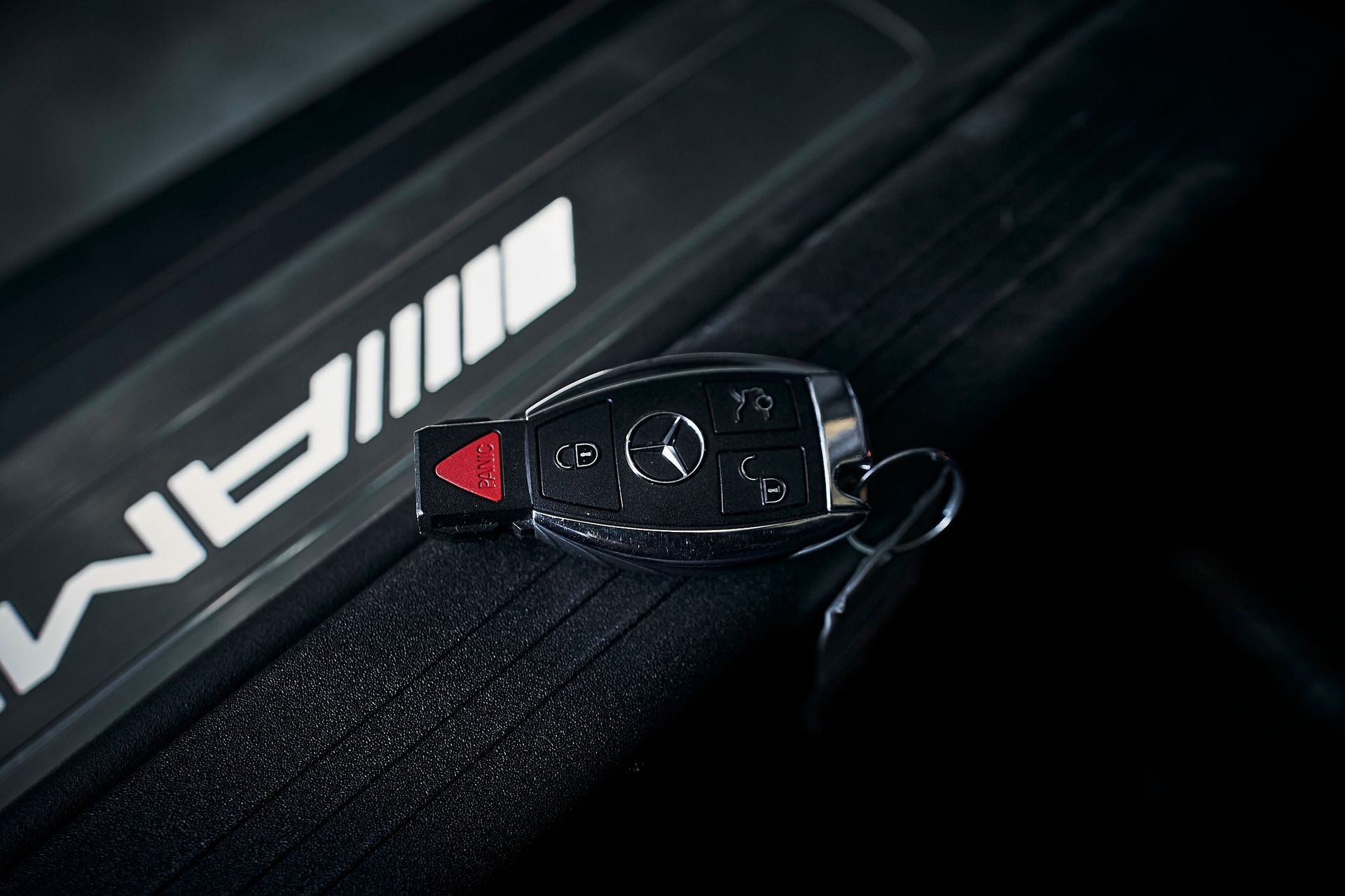 A close up of a car key on a car door.