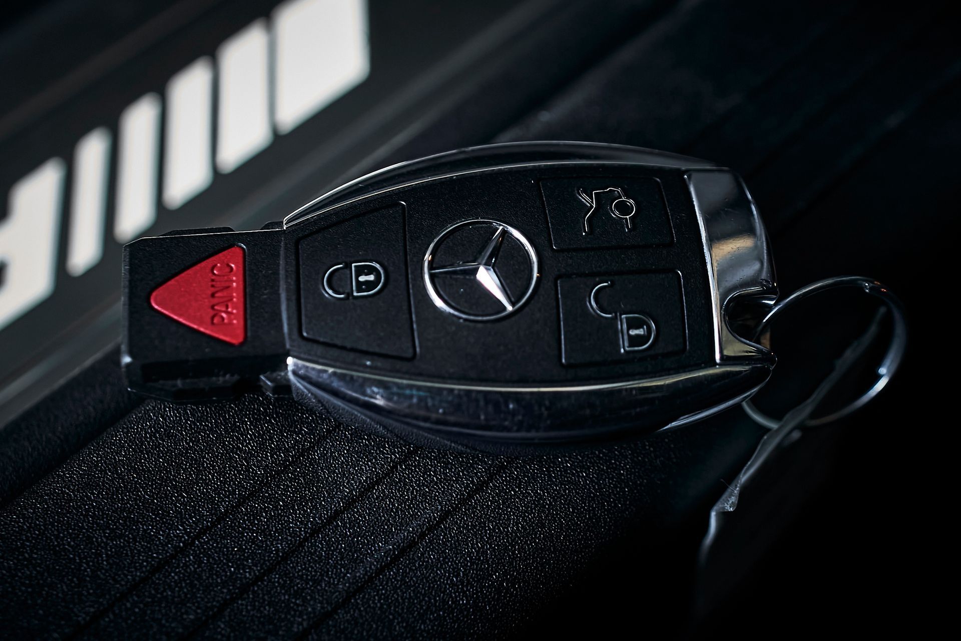 A close up of a mercedes key on a black surface