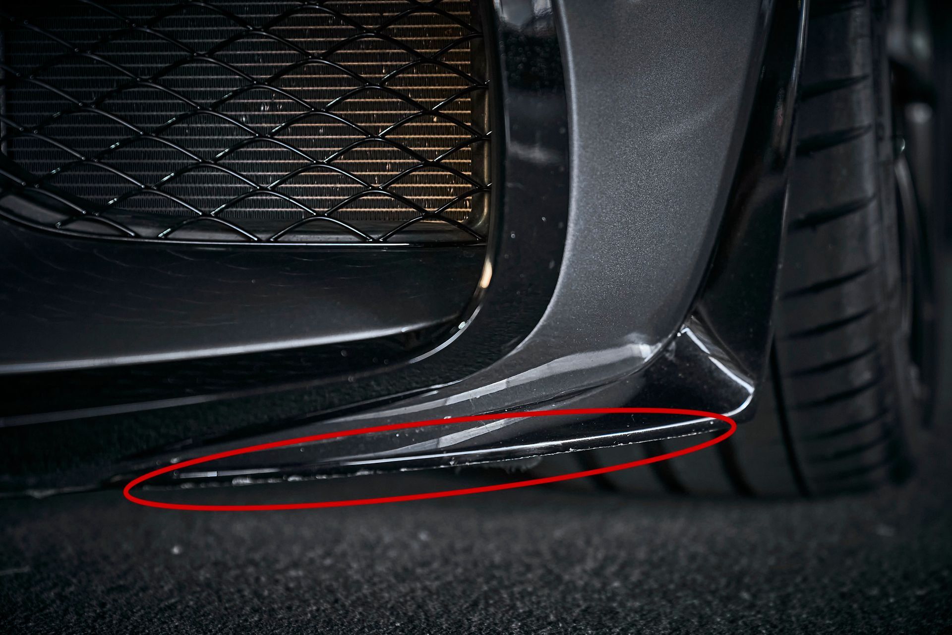 A close up of a car 's bumper with a red circle around it.