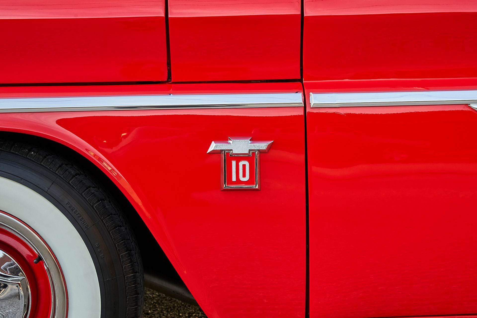 A red car with a chevrolet emblem on the side of it.