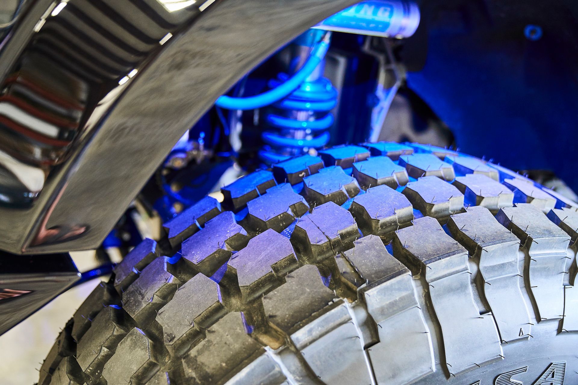 A close up of a tire on a truck with blue lights on it.