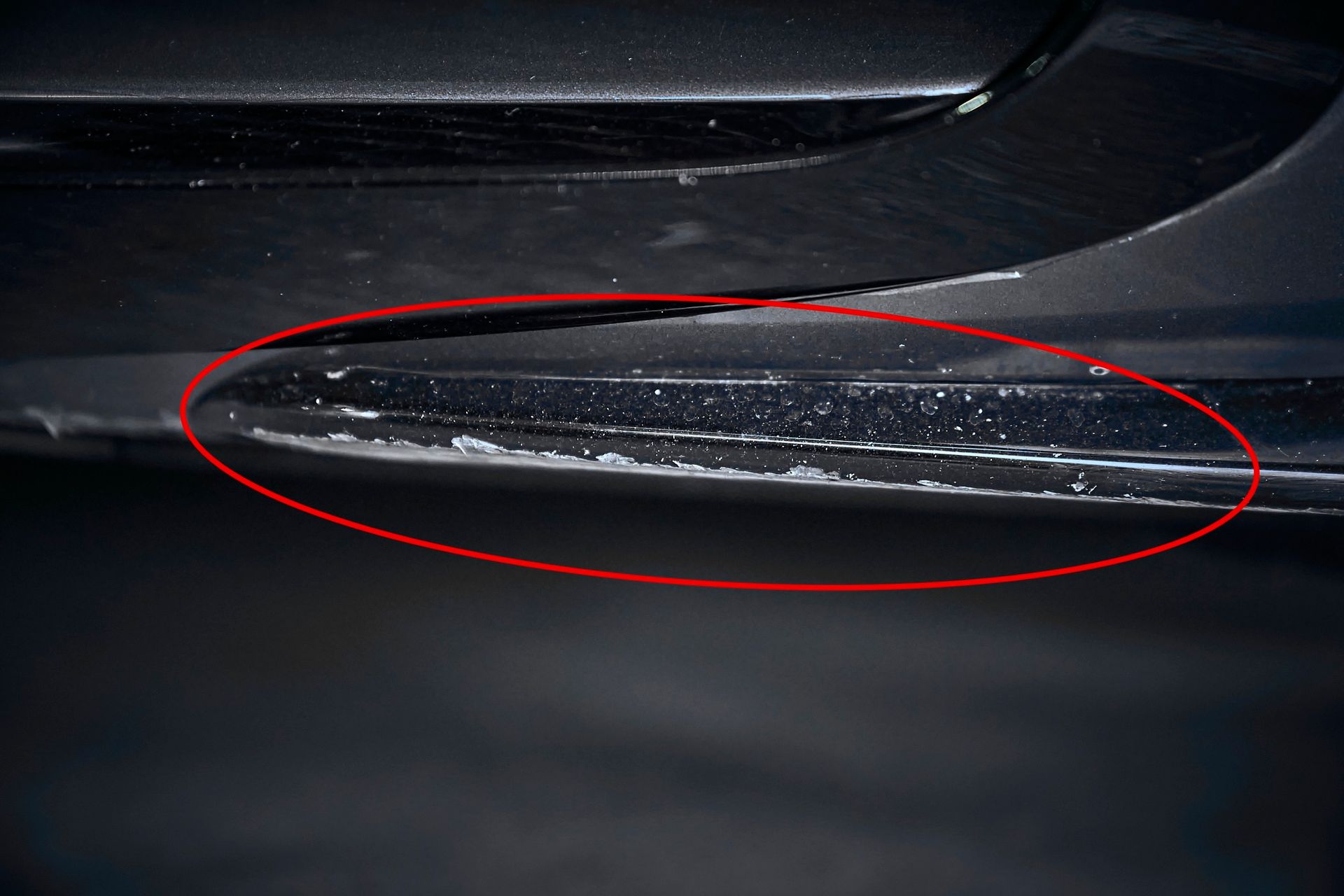 A close up of a car bumper with a red circle around it