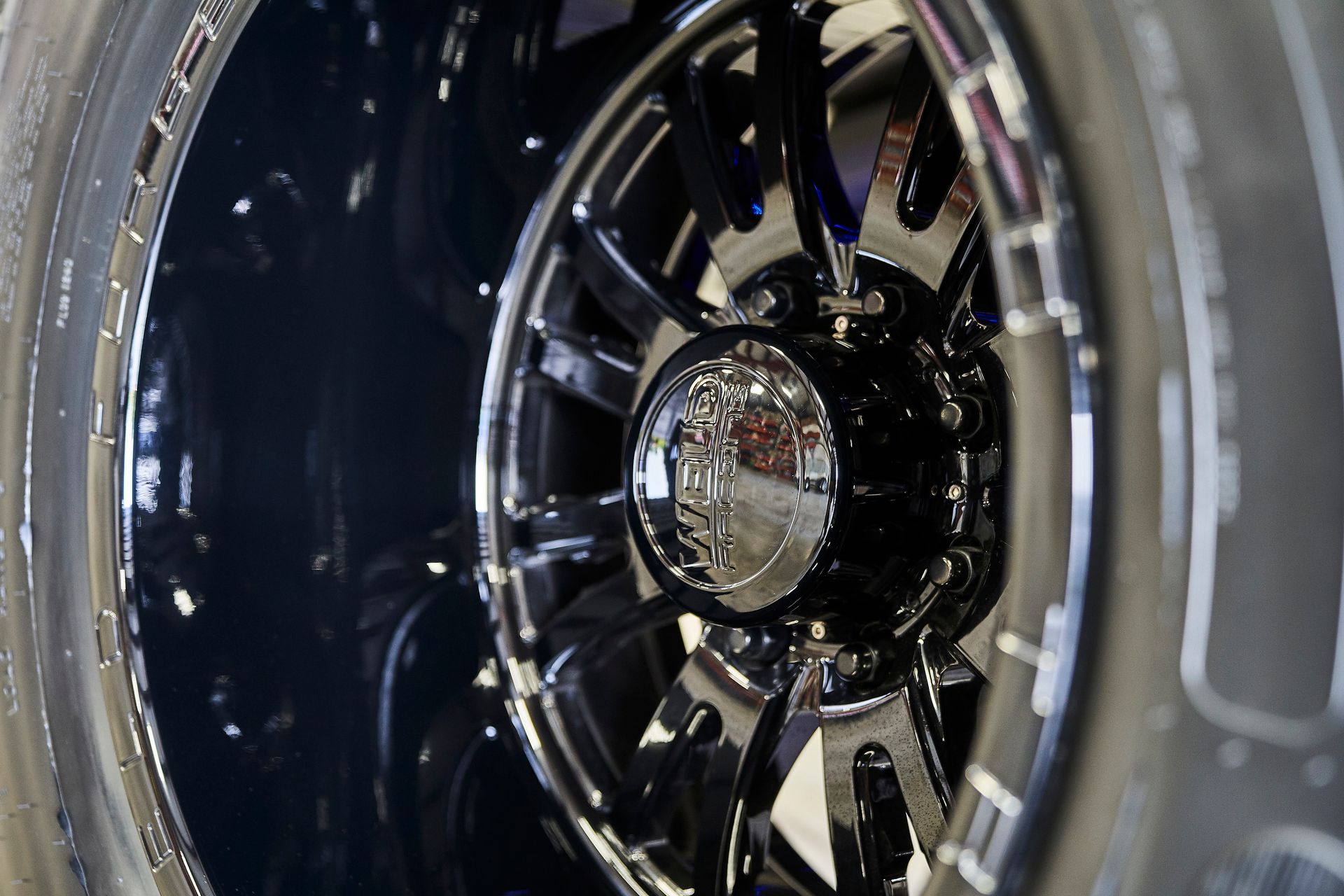 A close up of a car wheel with a tire in the background
