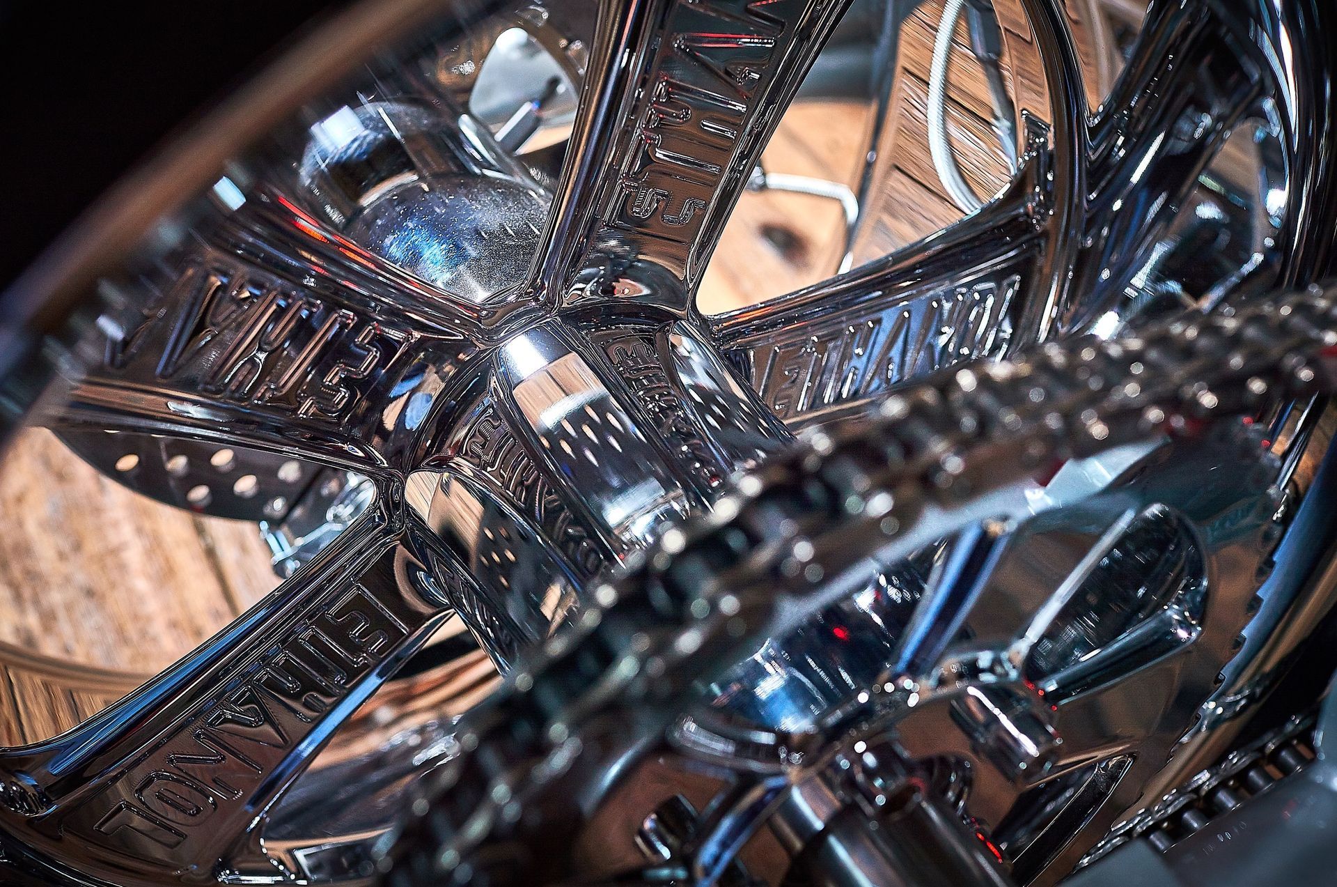 A close up of a motorcycle wheel with a chain attached to it.