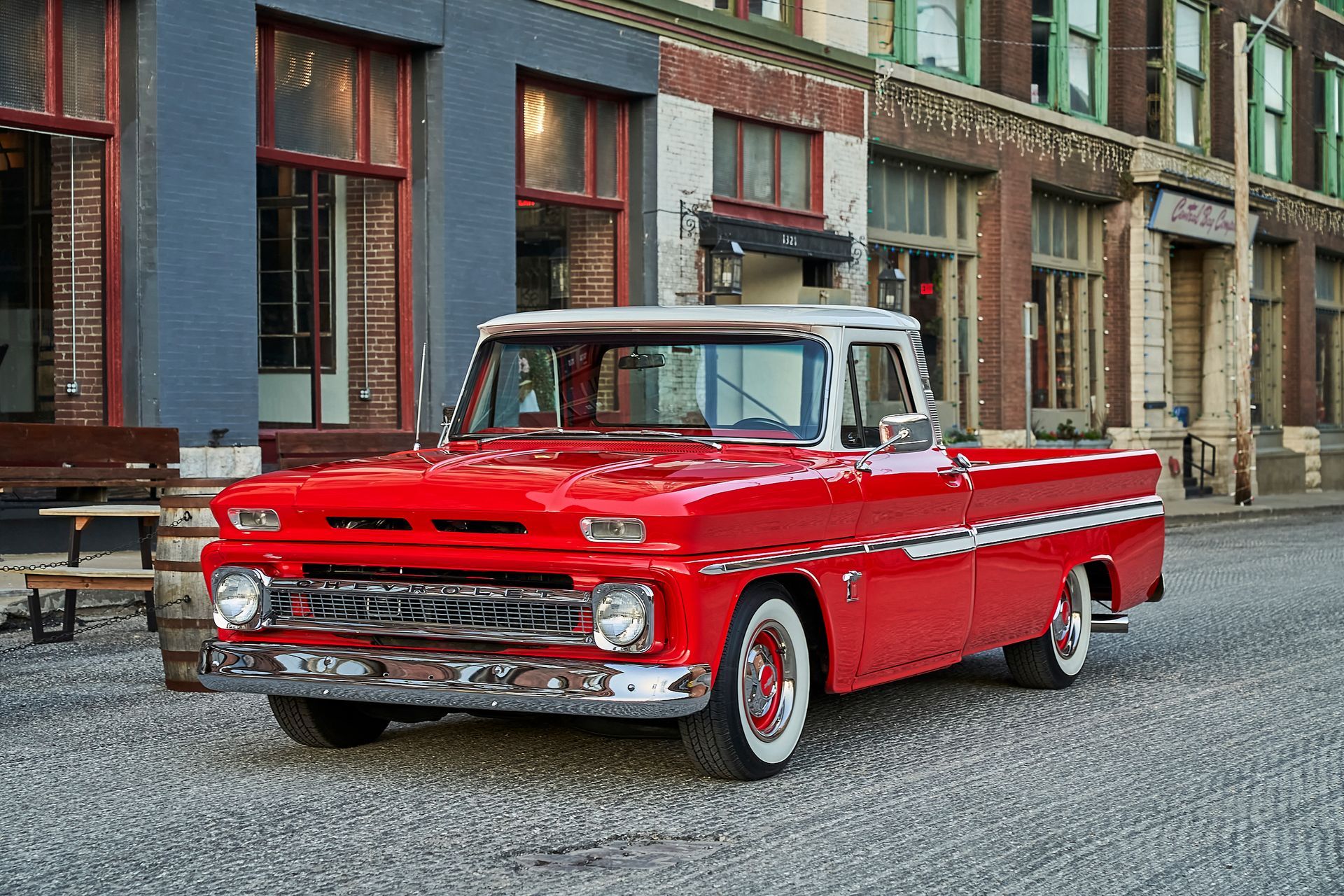 A red truck is parked in front of a building.