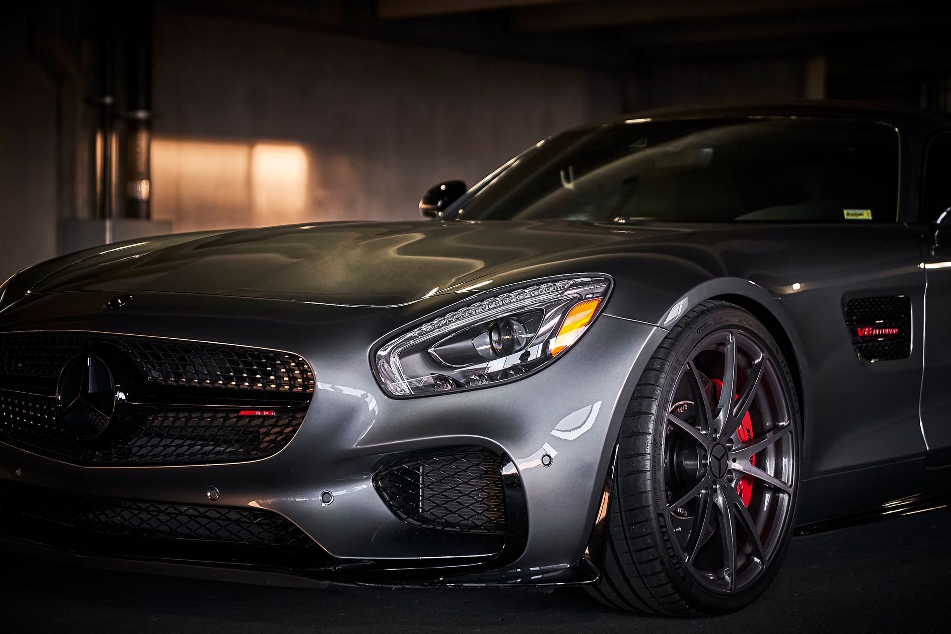A mercedes benz amg gt is parked in a dark parking garage.