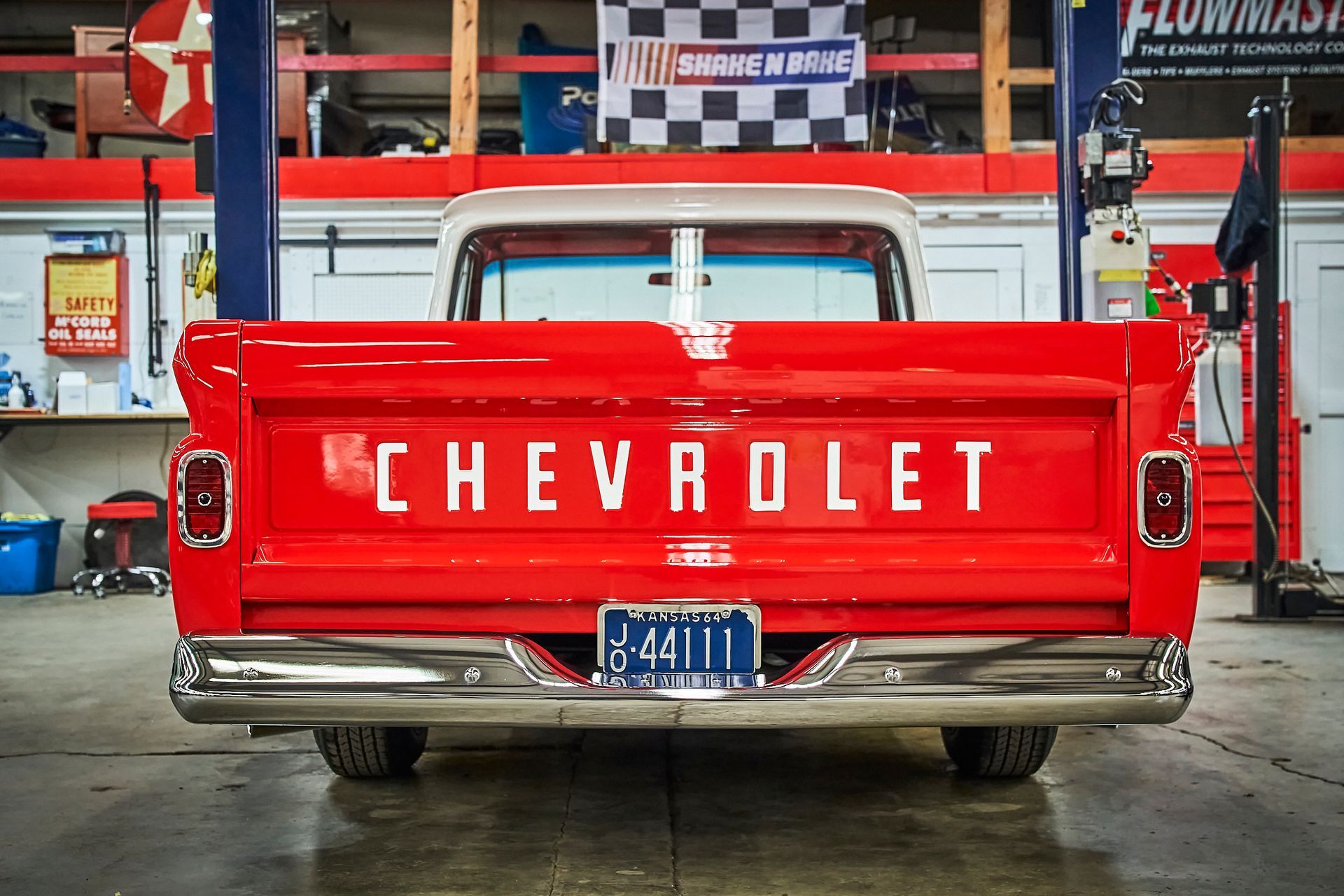 A red chevrolet truck is parked in a garage