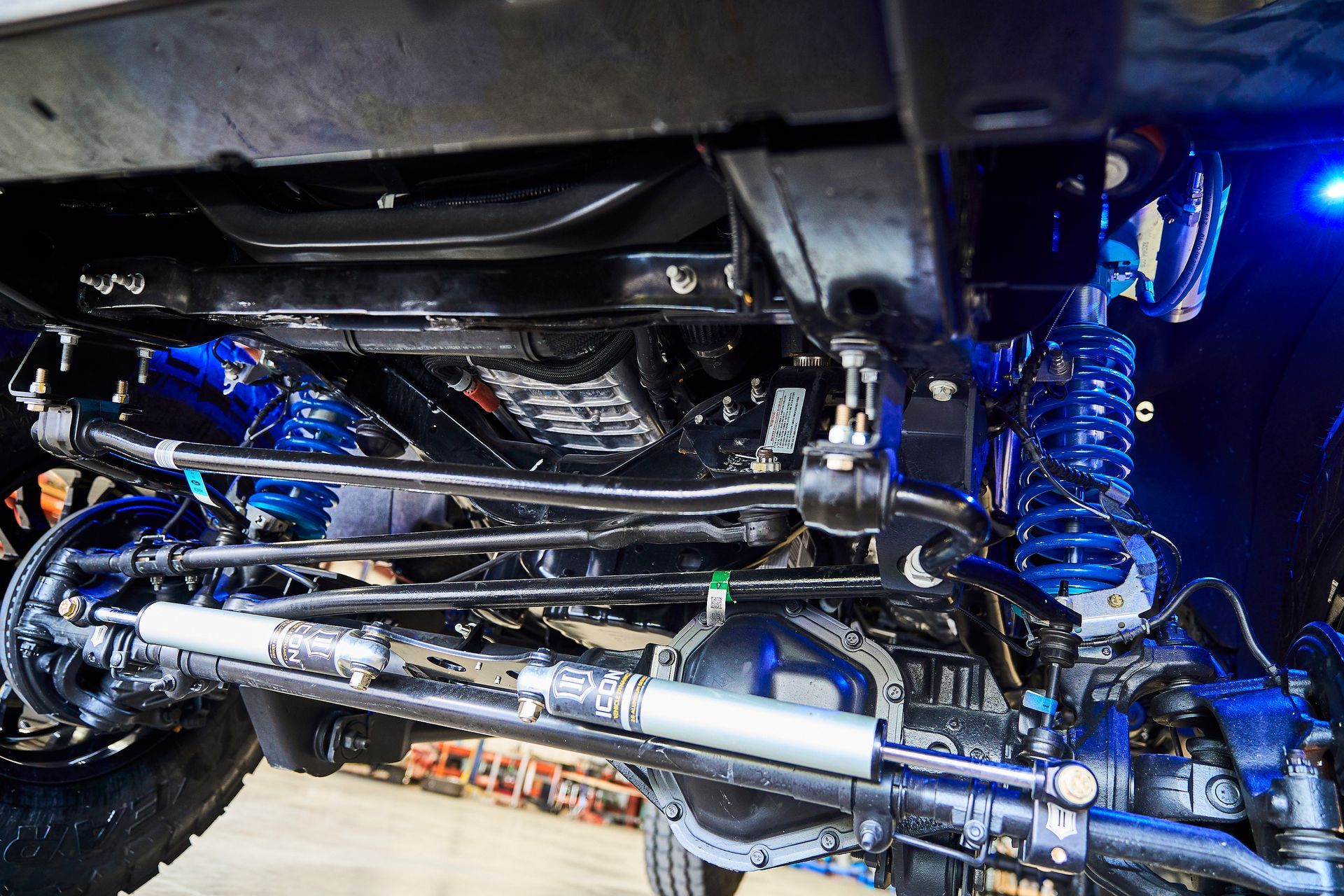 A close up of the underside of a truck with suspension and steering.