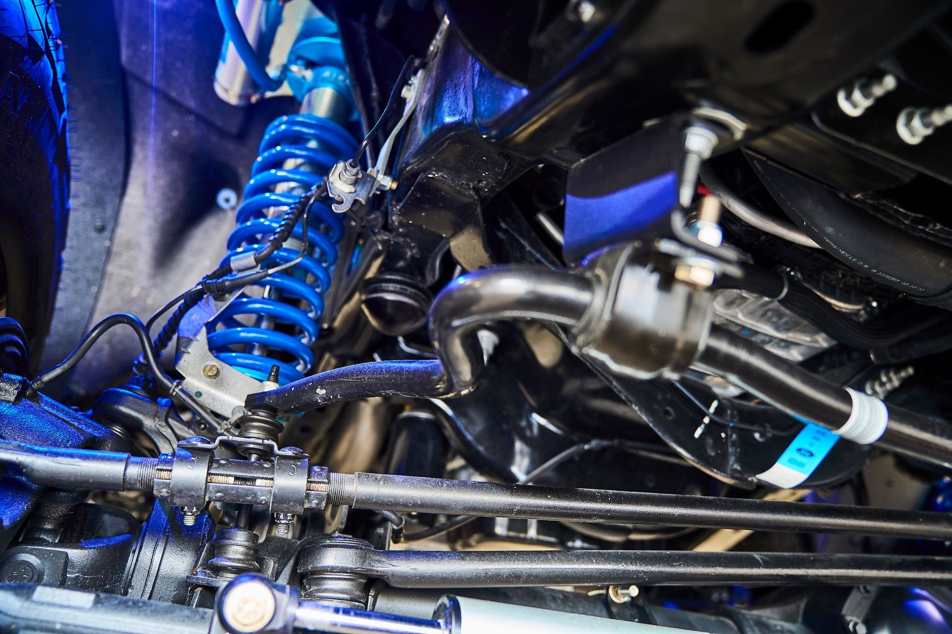 A close up of the underside of a car with suspension and steering.