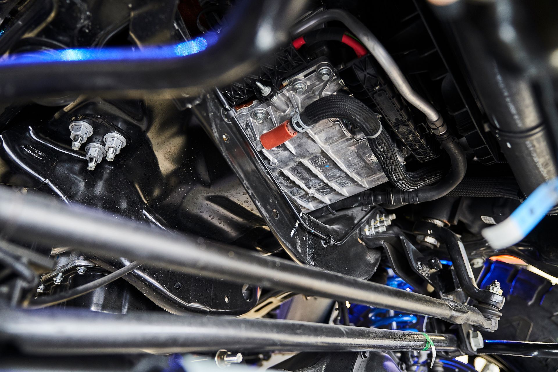 A close up of a car engine with a battery in it.