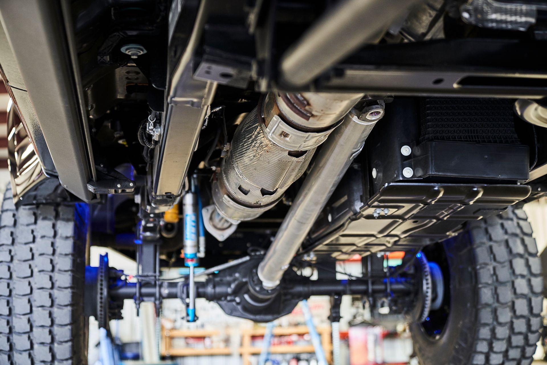 A close up of the underside of a truck in a garage.
