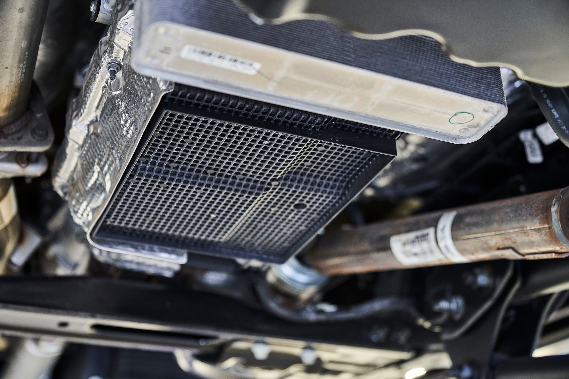 A close up of a radiator underneath a car.