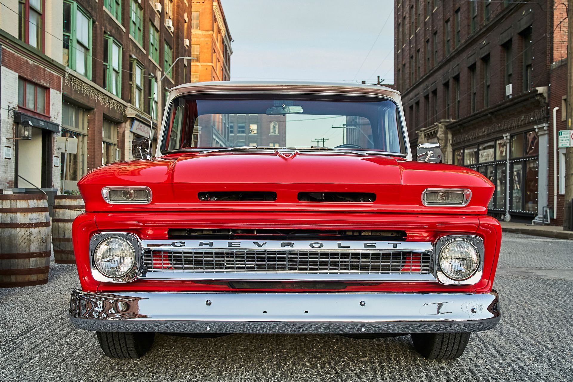 A red chevrolet truck is parked in front of a building