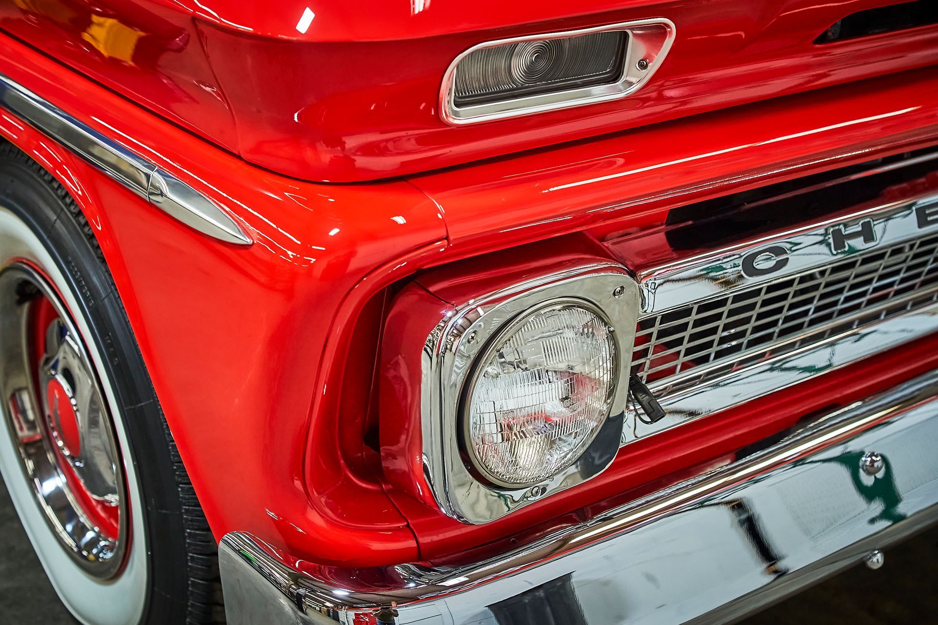 A close up of the front of a red chevrolet truck.