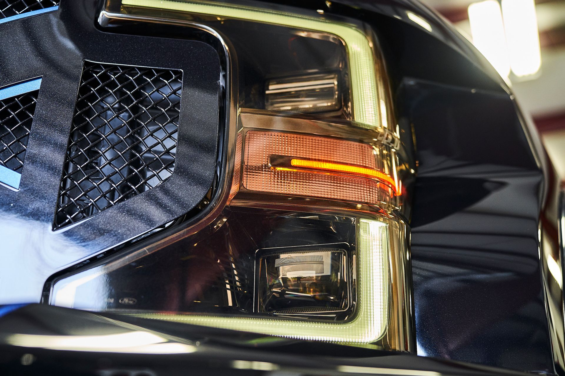 A close up of a car 's headlight and grille.