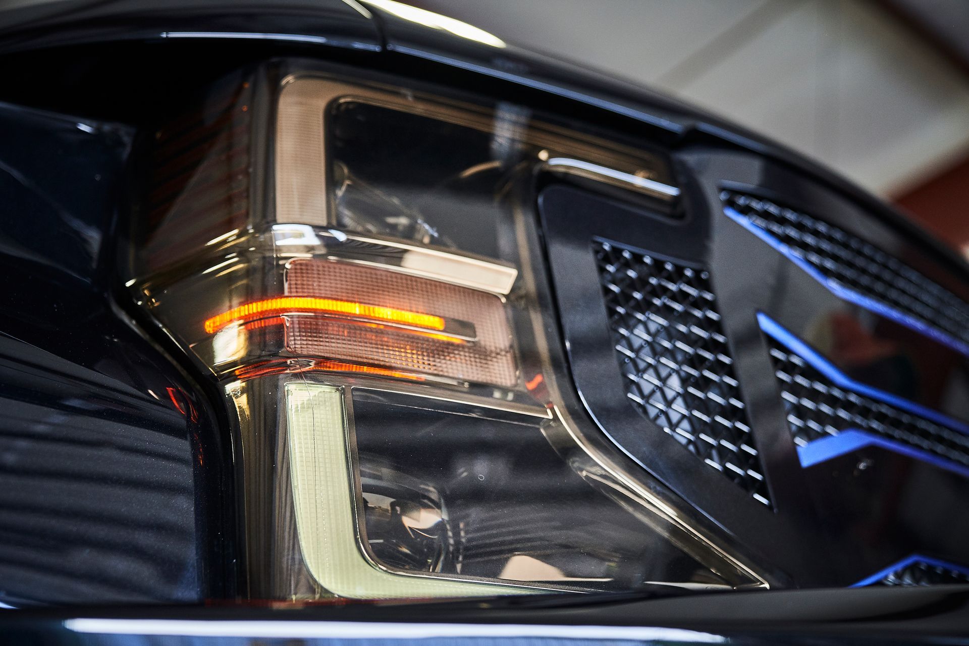 A close up of a car 's headlight in a garage.