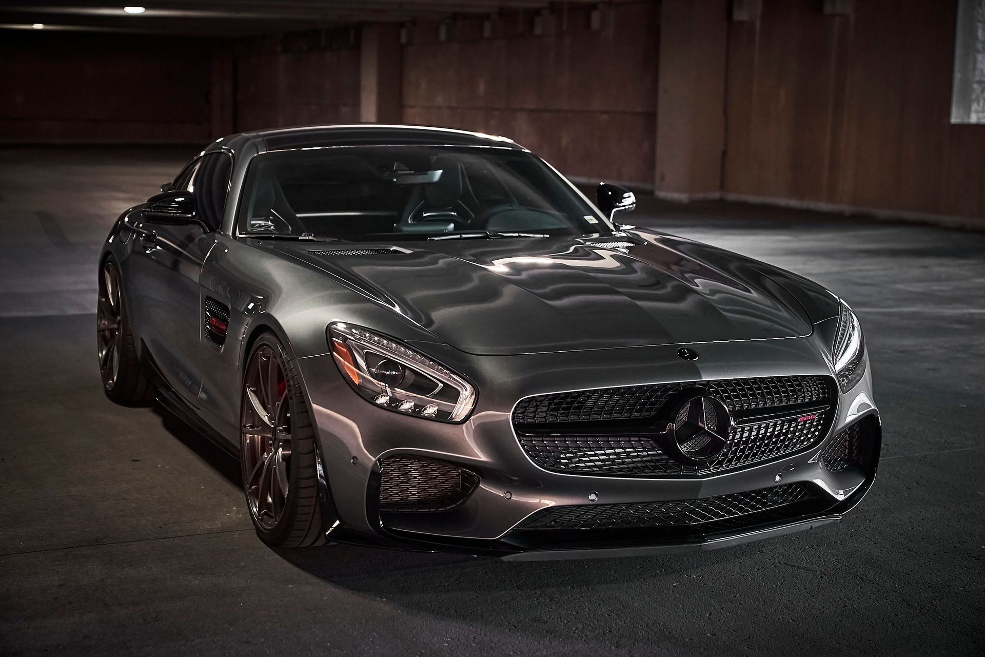 A mercedes benz sports car is parked in a parking garage.