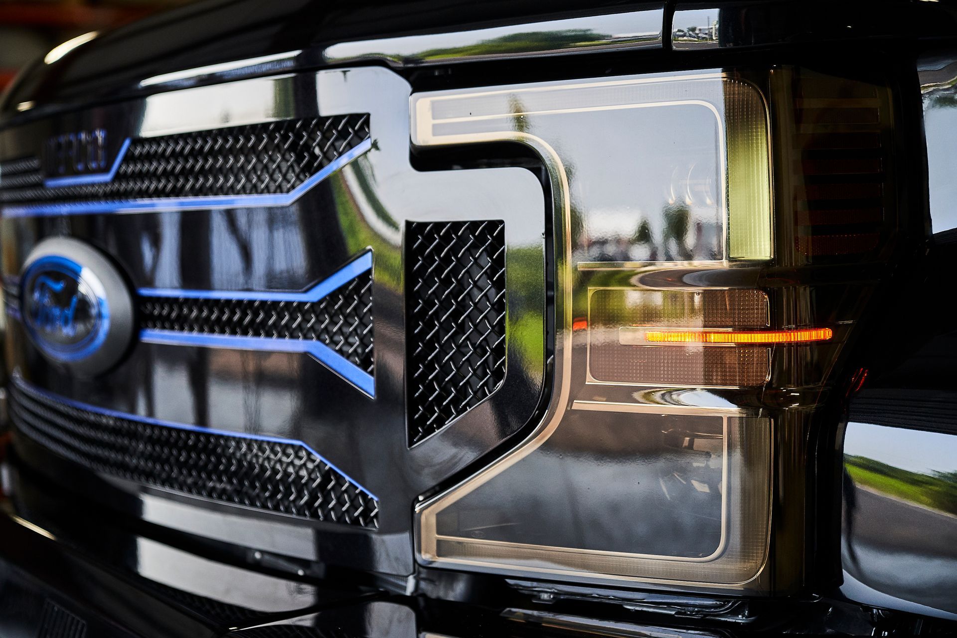 A close up of the front grille of a black ford truck.