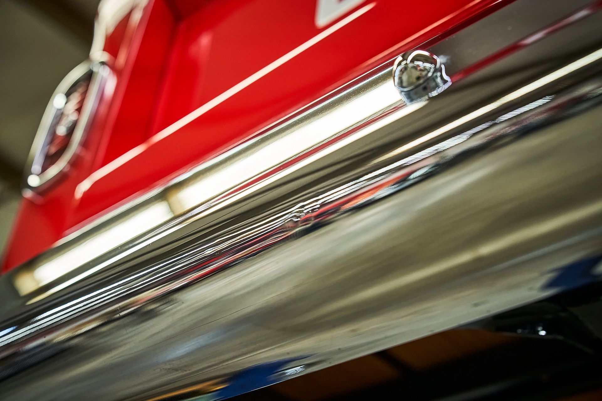 A close up of a red car with a chrome exhaust pipe