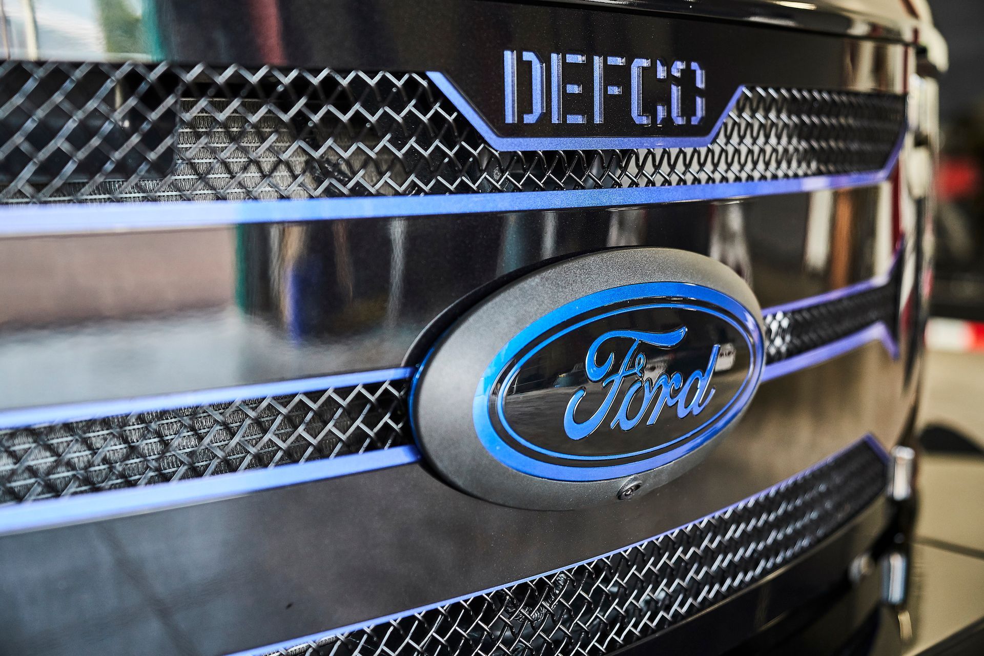 A close up of a ford logo on the front of a truck