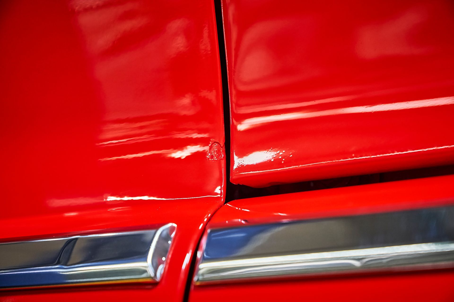 A close up of a red car with chrome trim.