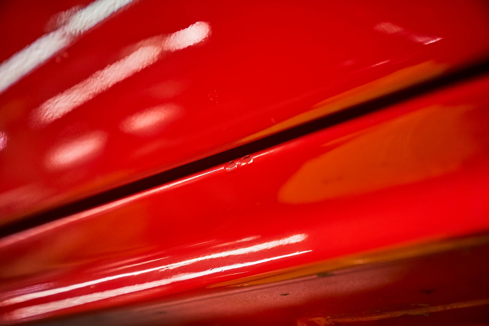 A close up of the side of a red car.