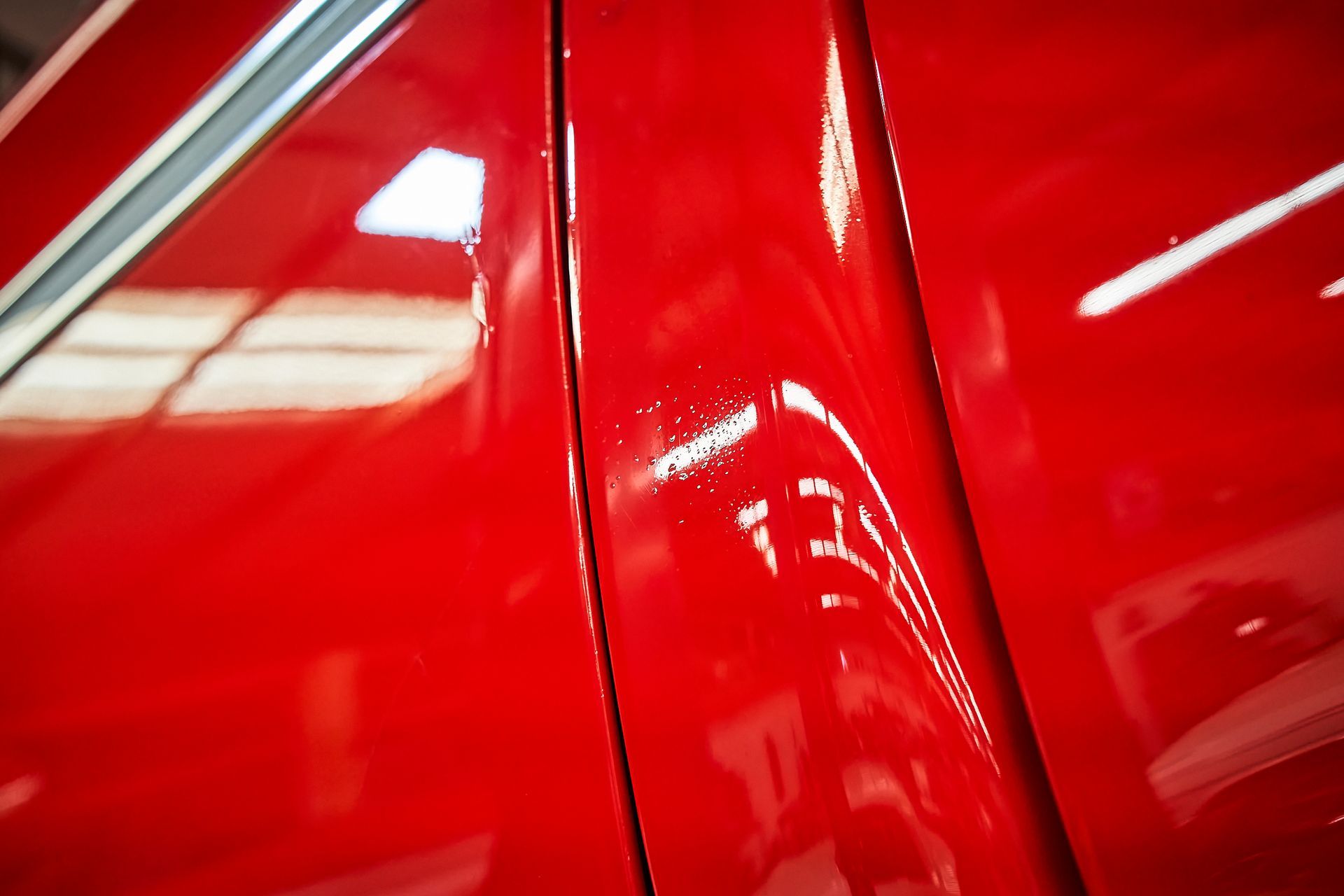 A close up of a red car door in a garage.