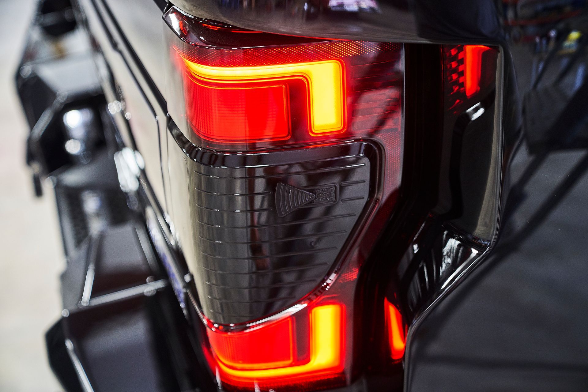 A close up of a black truck 's tail light.