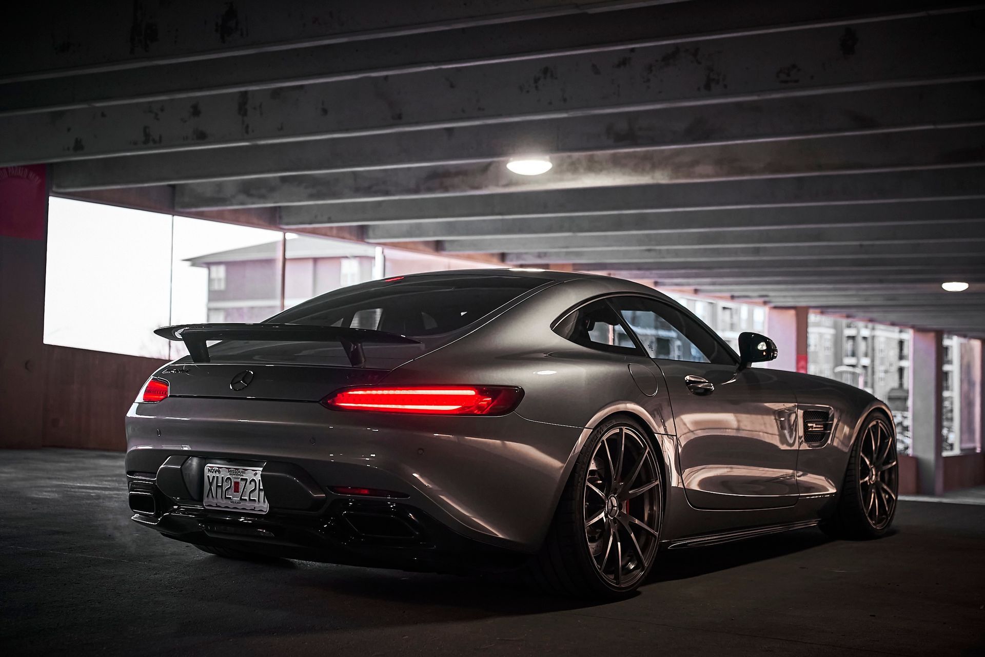 A mercedes amg gt is parked in a parking garage at night.
