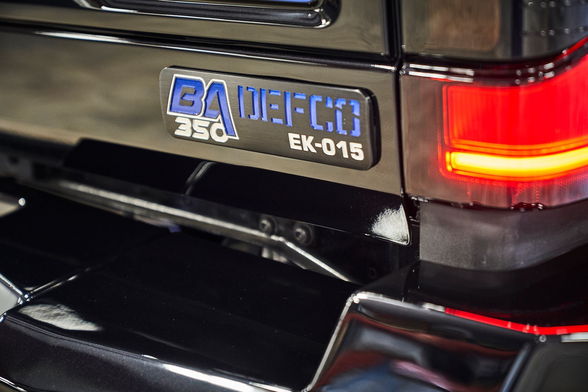 A close up of the back of a black car with a license plate that says ek-015